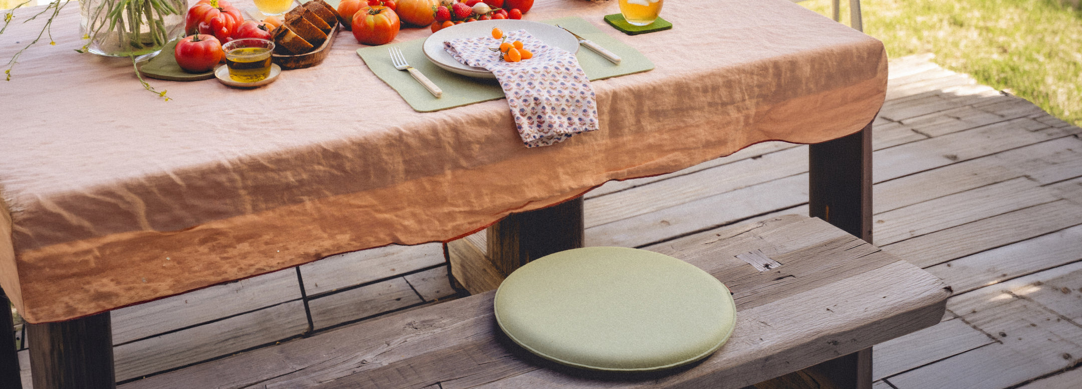 Green chair with a gray felt seat cushion, placed against a light striped wall.