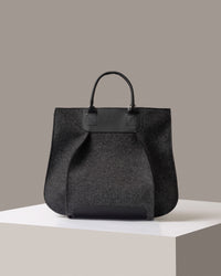 A timeless tote bag, Franke-collection by Graf Lantz, from Merino Wool in charcoal standing on a white base, front view