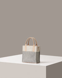 Rear view of a grey, white and beige Jaunt Mini Merino Wool Felt Tote bag by Graf Lantz featuring beige leather accents