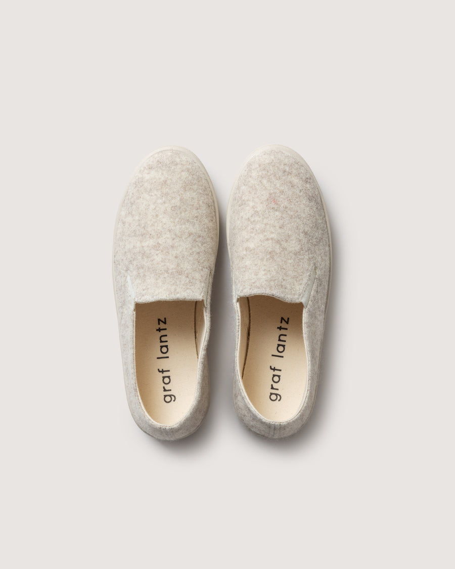 Our wool is breathable and durable, the soles are made from recycled rubber and the cotton canvas lining provides all-day comfort:  Haus Merino Wool Felt Slip-on. Here in heather cream color.