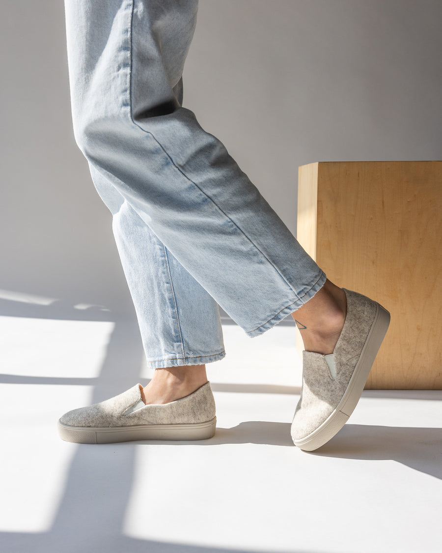 Our wool is breathable, durable, and elegant, the soles are made from recycled rubber and the cotton canvas lining provides all-day comfort:  Haus Merino Wool Felt Slip-on. Here in heather cream color