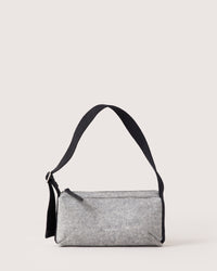 A stylish graf lantz Campus Shoulder Bag in gray, featuring a long black strap and a soft texture reminiscent of Merino Wool. Its perfect for carrying everyday essentials and is shown laying flat against a white background.