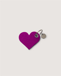 The Graf Lantz heart-shaped keychain, crafted from purple felt with a small round silver metal tag and attached to a metal keyring, is a charming and sustainable accessory shown on a plain white background.