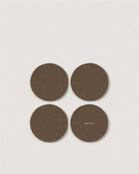 Four round, brown Merino wool coasters by Graf Lantz are arranged in a square on a white background. One features “graf lantz” in small white text near the edge—a refined detail for eco-friendly home decor.