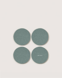 Four round, teal Merino wool coasters by Graf Lantz are arranged in a square on a light background. One features the small white Graf Lantz logo, adding stylish, sustainable flair to your home decor.