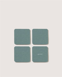 Four square, teal Merino wool coasters by Graf Lantz are arranged in a grid on a light background. One features small white graf lantz text—an elegant detail for sustainable home décor.