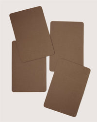 Four blank brown rectangular Graf Lantz cards with rounded corners are arranged in an overlapping, scattered pattern on a light background—ideal for inspiring sustainable table decor or designer settings.