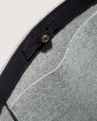 A close-up of the interior of a graf lantz gray felt hat showcases its black inner band and a small silver button with stitching. Made from sustainable materials, the fabric texture stands out against a light background, reminiscent of high-quality Merino Wool accessories.