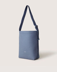 The Graf Lantz sustainable blue shoulder bag is made from Merino Wool and has a minimalist design with an adjustable strap. Perfect for daily use, it stands upright against a plain white backdrop.