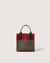 A small rectangular Graf Lantz handbag featuring dark brown and deep red panels, black handles, and visible stitching, displayed against a plain light background.