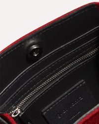 Close-up of the inside of a black leather Graf Lantz wallet with a red trim, featuring a silver zipper pocket, snap button closure, and the partially visible embossed brand name on a card slot.