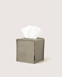 A square, gray Graf Lantz Merino wool tissue box cover with a white tissue emerging from the top, set against a light background—ideal for minimalist home décor.
