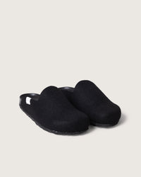 A pair of black slip-on clogs by graf lantz, featuring a rounded toe and recycled rubber soles, set against a plain light gray background.