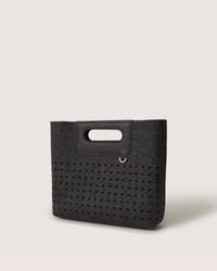 A graf lantz dark gray Merino Wool rectangular tote bag features a cutout handle and small circular perforations on the lower half. Set against a light neutral background, it highlights the minimalist design.