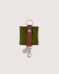 A Merino Wool Pod Key Fob in Moss color with brown leather application, white background
