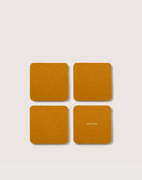 Four orange Merino wool coasters from graf lantz are arranged in a 2x2 grid on a white background, with graf lantz printed in white on the lower right coaster.