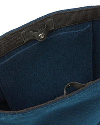 Close-up of a graf lantz blue felt bag interior, designed for daily use with multiple pockets and a black strap featuring a button closure. Its soft material and minimalist design embody sustainable elegance.