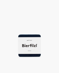 A square dark blue Bierfilzl coaster, made from sustainable German Merino wool with rounded edges by graf lantz, is centered on a plain white background.