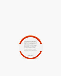 A round orange coaster by graf lantz features text on the white surface offering historical coaster info and web links. The edge is bordered with fine German Merino wool.