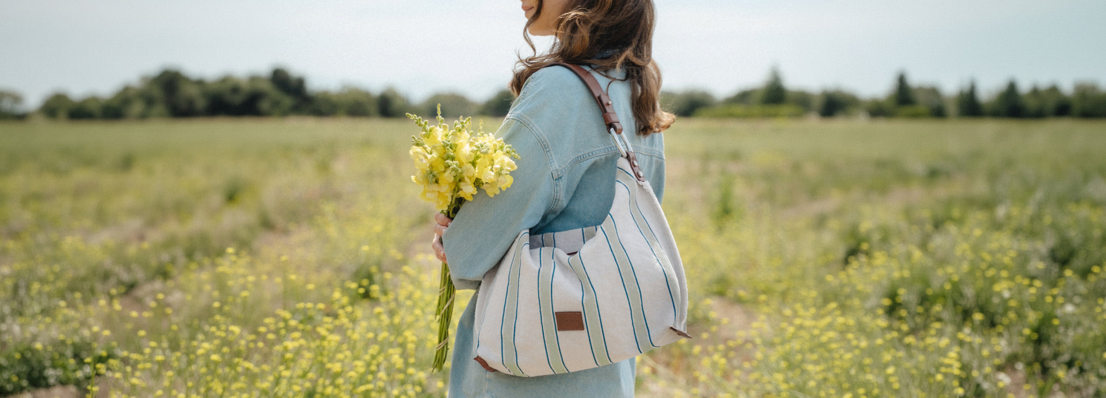Person wearing a beige dress holds a tan crossbody bag. Text on image: 30% Off Sitewide. Small print: *Excludes everyday icons and final sale.