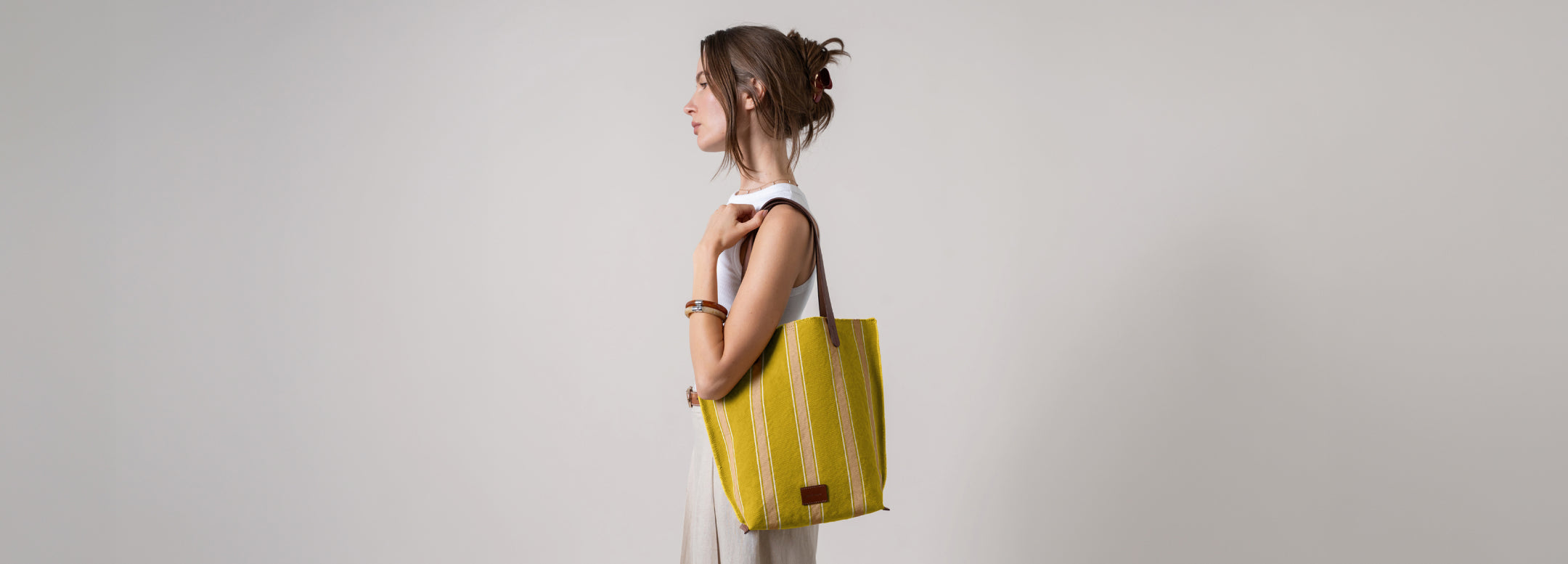 Woman sitting in green grass next to yellow Hako Cotton Canvas Tote bag by Graf Lantz