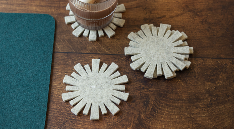 A model wearing a linen romper jumpsuit carries the Bedford Midi Backpack in Heather White trimmed with vegetable-tanned leather in Sienna brown