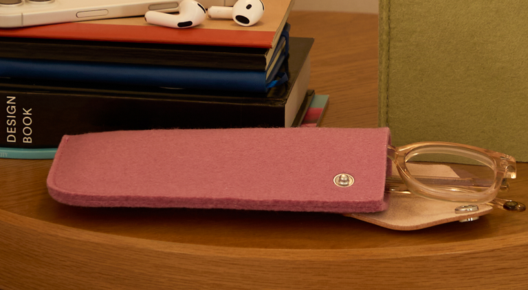 A laptop displaying 6:33 sits on a wooden desk with a mouse, pencil, plant, framed photo, books, notepad, and charging cables neatly arranged around it.
