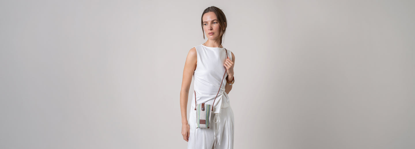 A person in a light dress holds a large handbag against a green leafy background. Text reads: 30% Off Bags - Spring Clean Sale. *Excludes everyday icons and final sale.