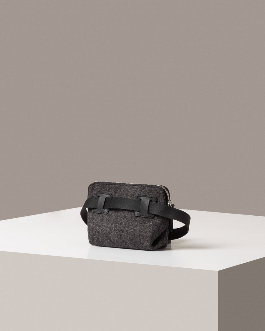 Rear view of a dark gray Bedford Merino Wool Felt Belt Bag by Graf Lantz featuring an extra-long black strap