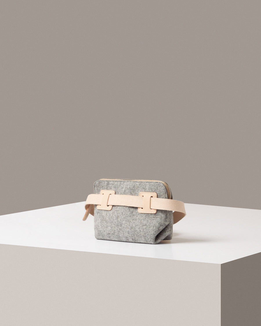 Rear view of a gray Bedford Merino Wool Felt Belt Bag by Graf Lantz featuring an extra-long beige strap