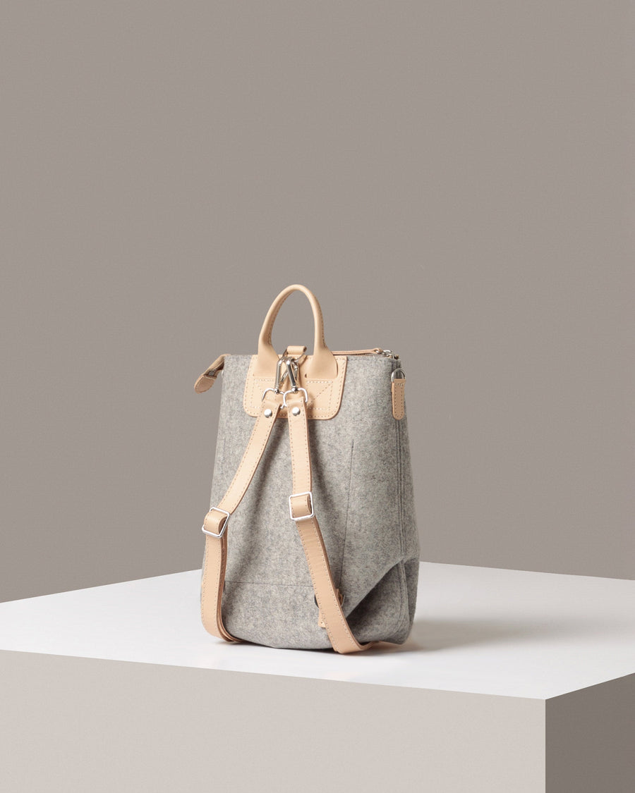 Rear view of a granite-colored Bedford Merino Wool Felt Midi Backpack by Graf Lantz featuring beige leather shoulder straps