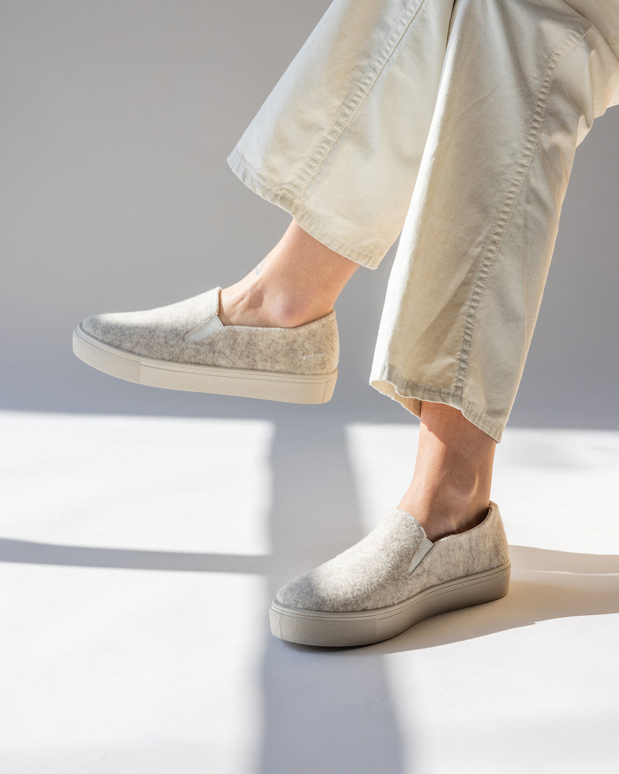 Our wool is breathable, durable, and elegant, the soles are made from recycled rubber and the cotton canvas lining provides all-day comfort:  Haus Merino Wool Felt Slip-on. Here in heather cream color