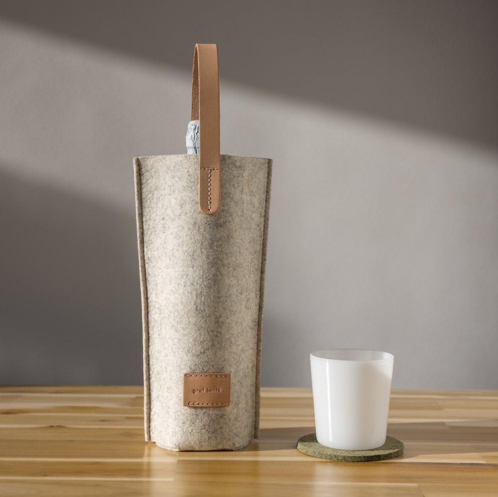 Heather white colored Merino wool felt bottle bag with natural colored leather handle