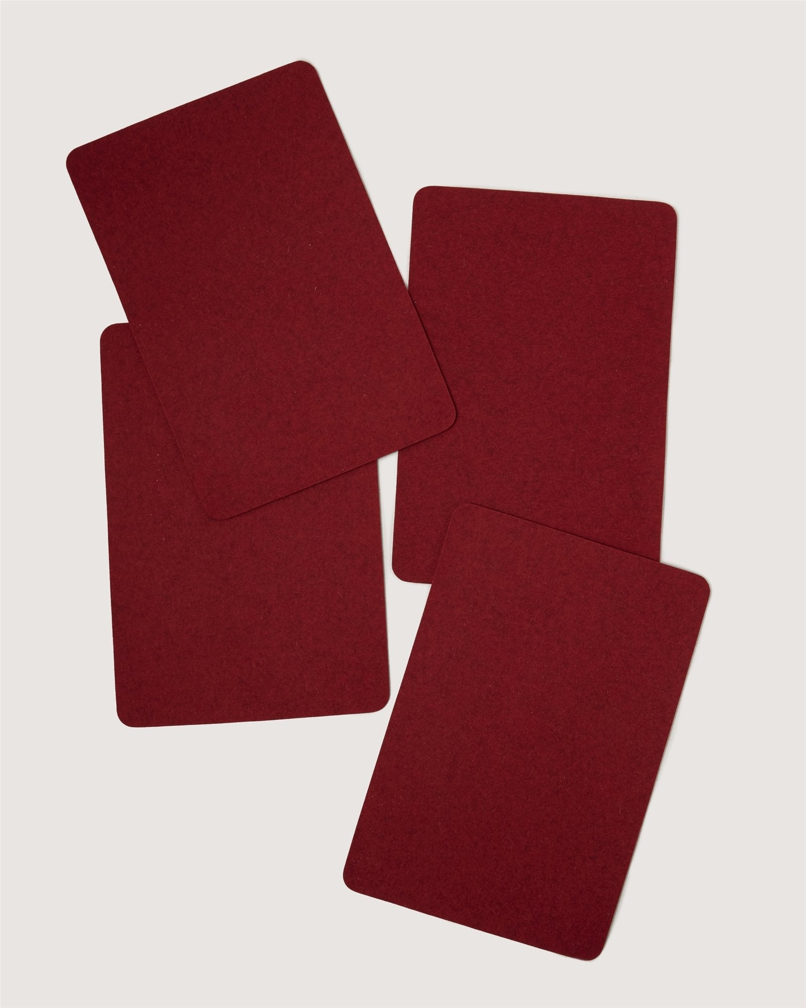 Four red Graf Lantz playing cards are laid out face down on a plain, light background, slightly overlapping each other at random angles.