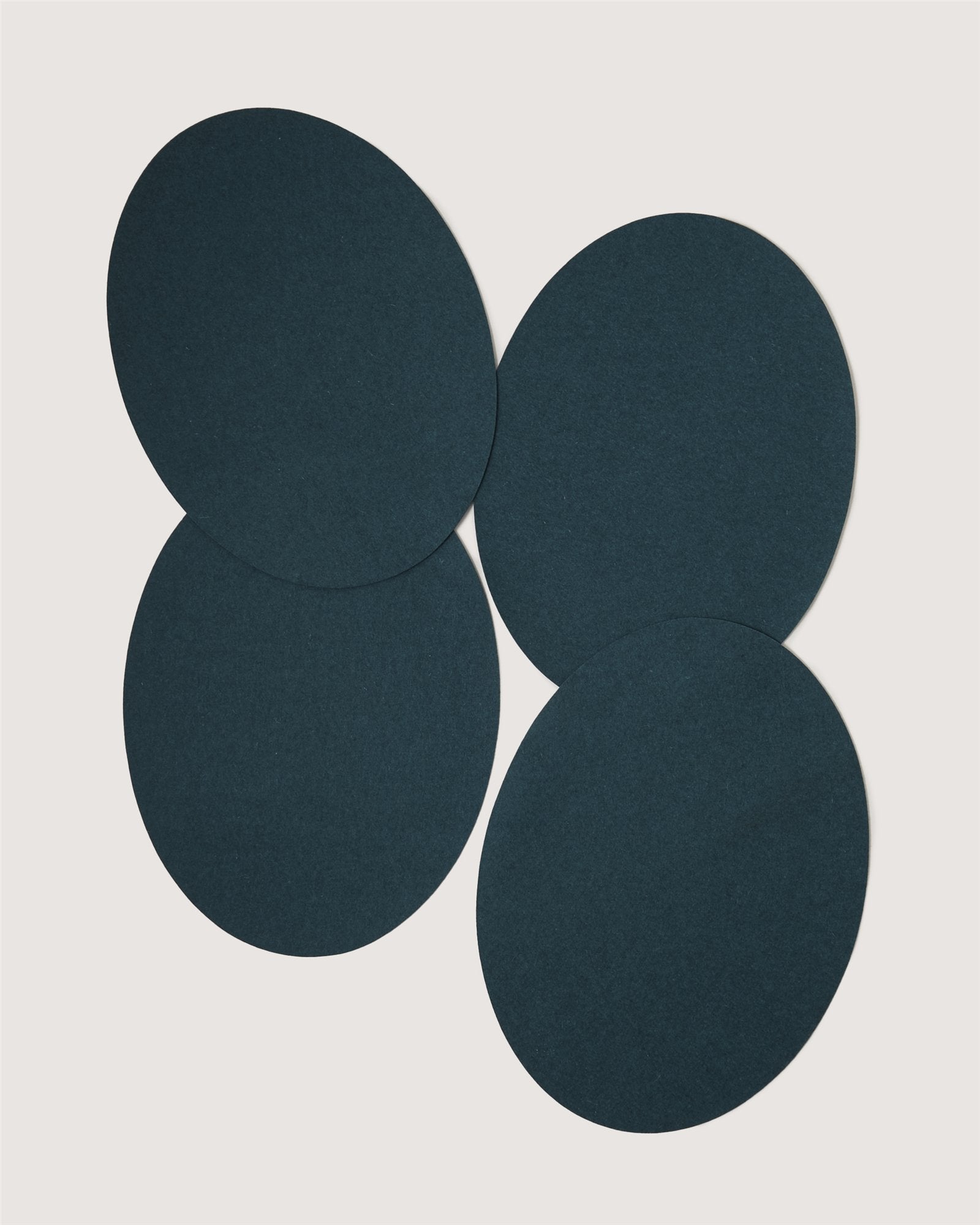 Four dark blue circular felt pads by Graf Lantz, overlapping slightly and arranged on a plain white background.
