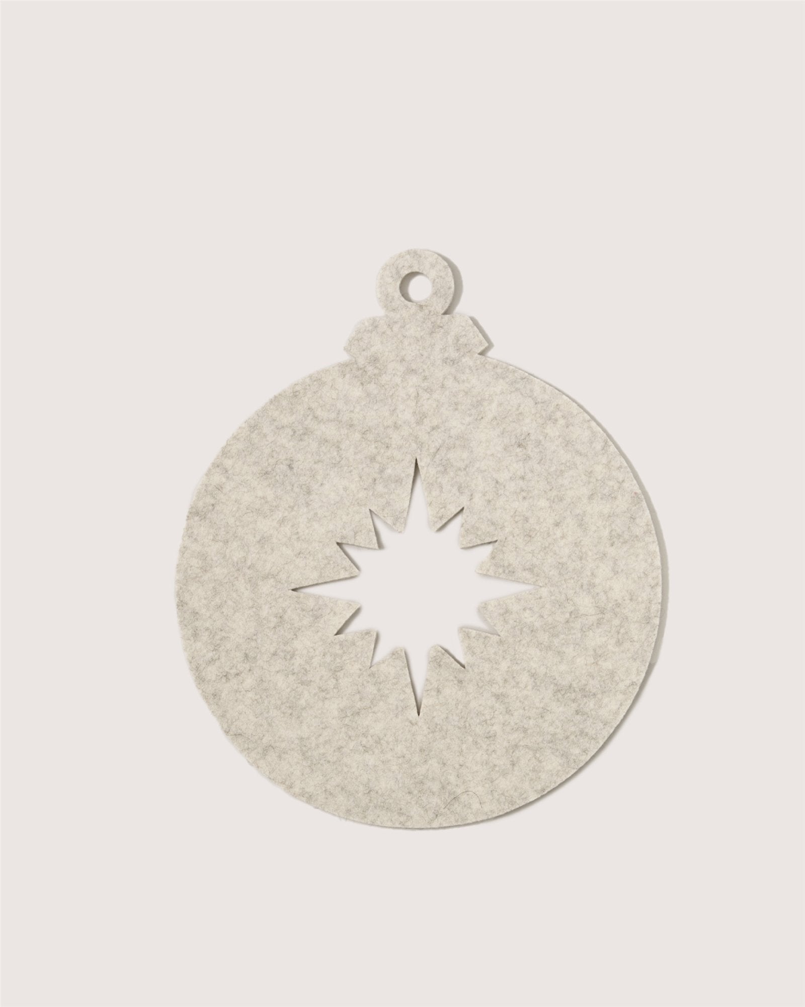A flat, round, light gray felt ornament by Graf Lantz, shaped like a Christmas bauble with a starburst cutout in the center and a small hole at the top for hanging, set against a plain white background.