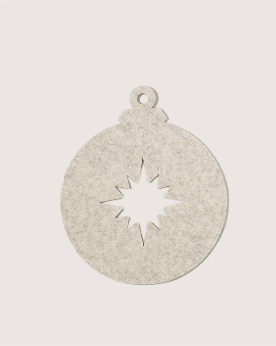 A flat, round, light gray felt ornament by Graf Lantz, shaped like a Christmas bauble with a starburst cutout in the center and a small hole at the top for hanging, set against a plain white background.