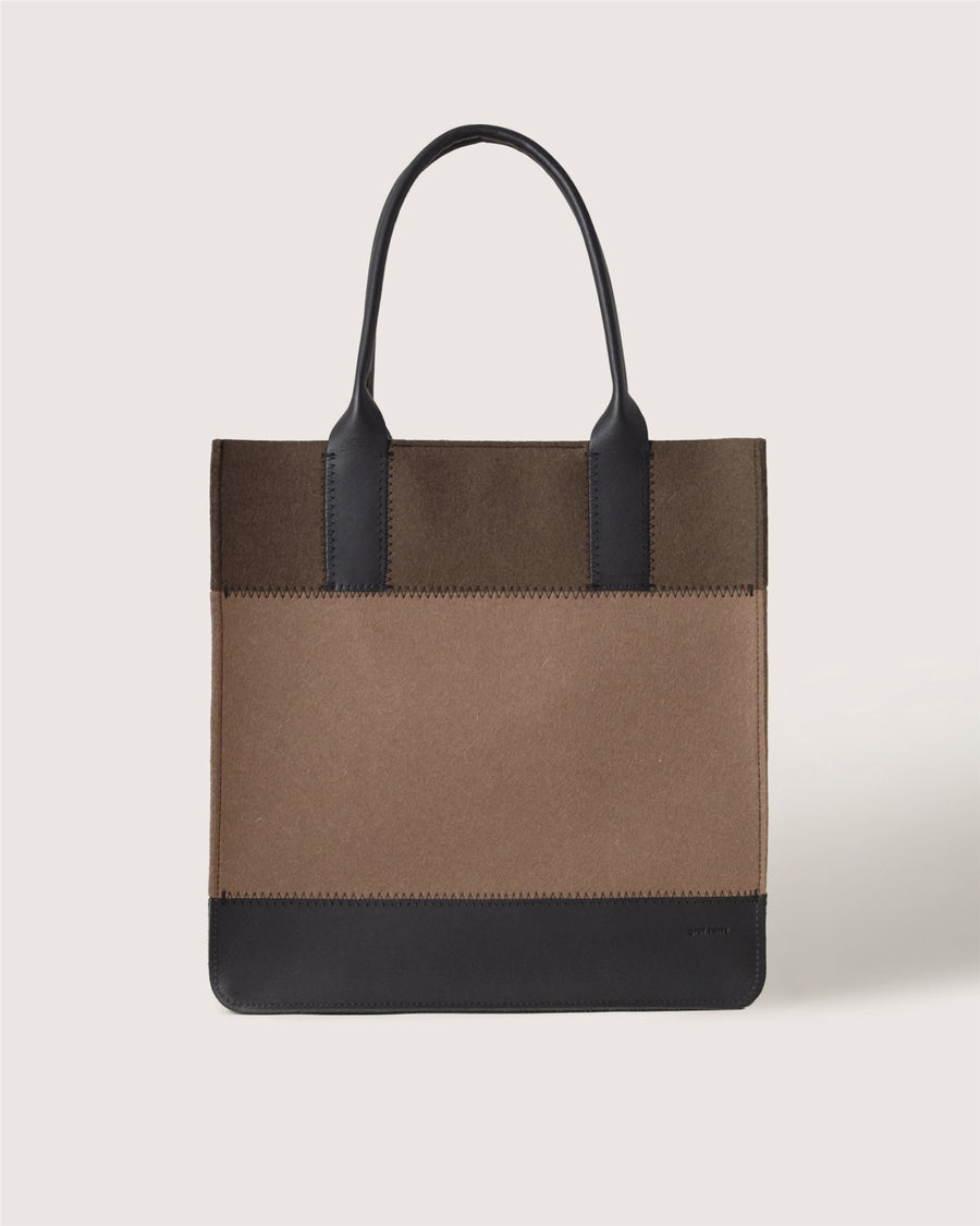 A Graf Lantz rectangular tote bag with two black handles, a brown body, and black trim at the top and bottom is displayed against a plain light background.