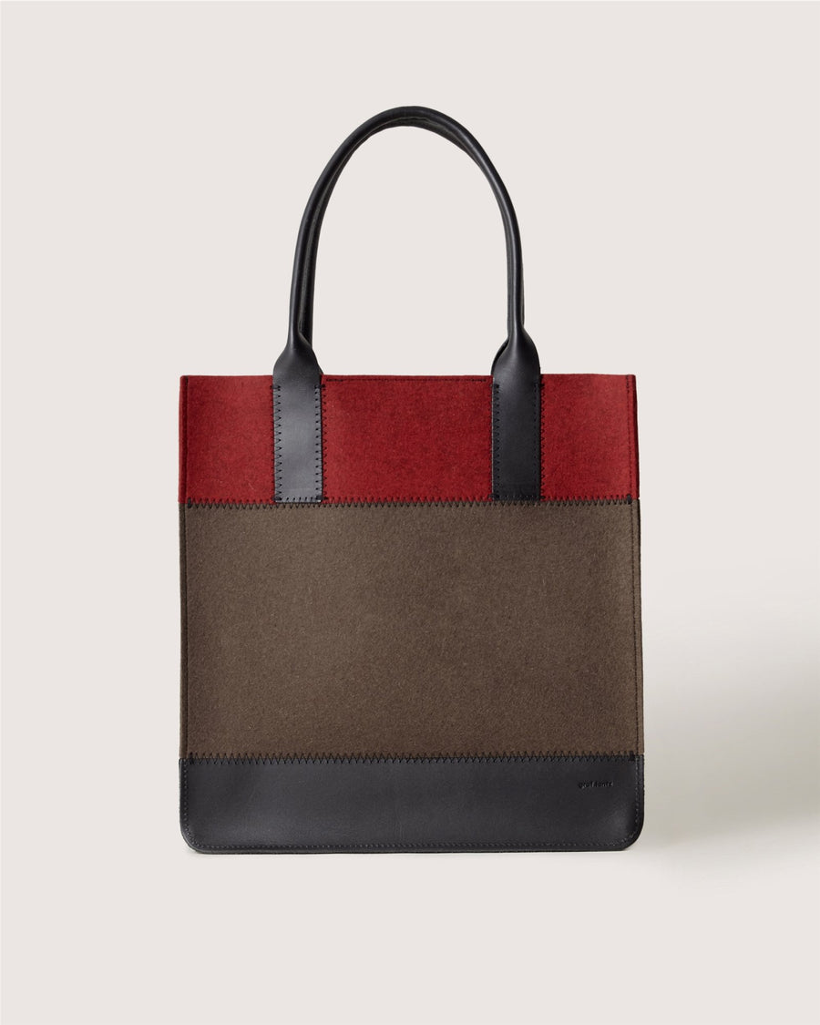 A structured Graf Lantz tote bag with black handles, a dark red top, brown middle section, and black bottom trim is displayed against a plain light background.