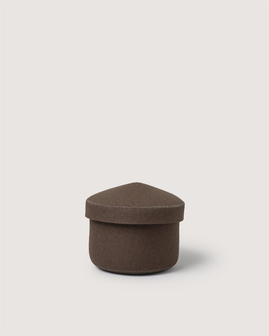 A small, round brown fabric box by Graf Lantz features a slightly domed, triangular lid and is set against a plain white background.