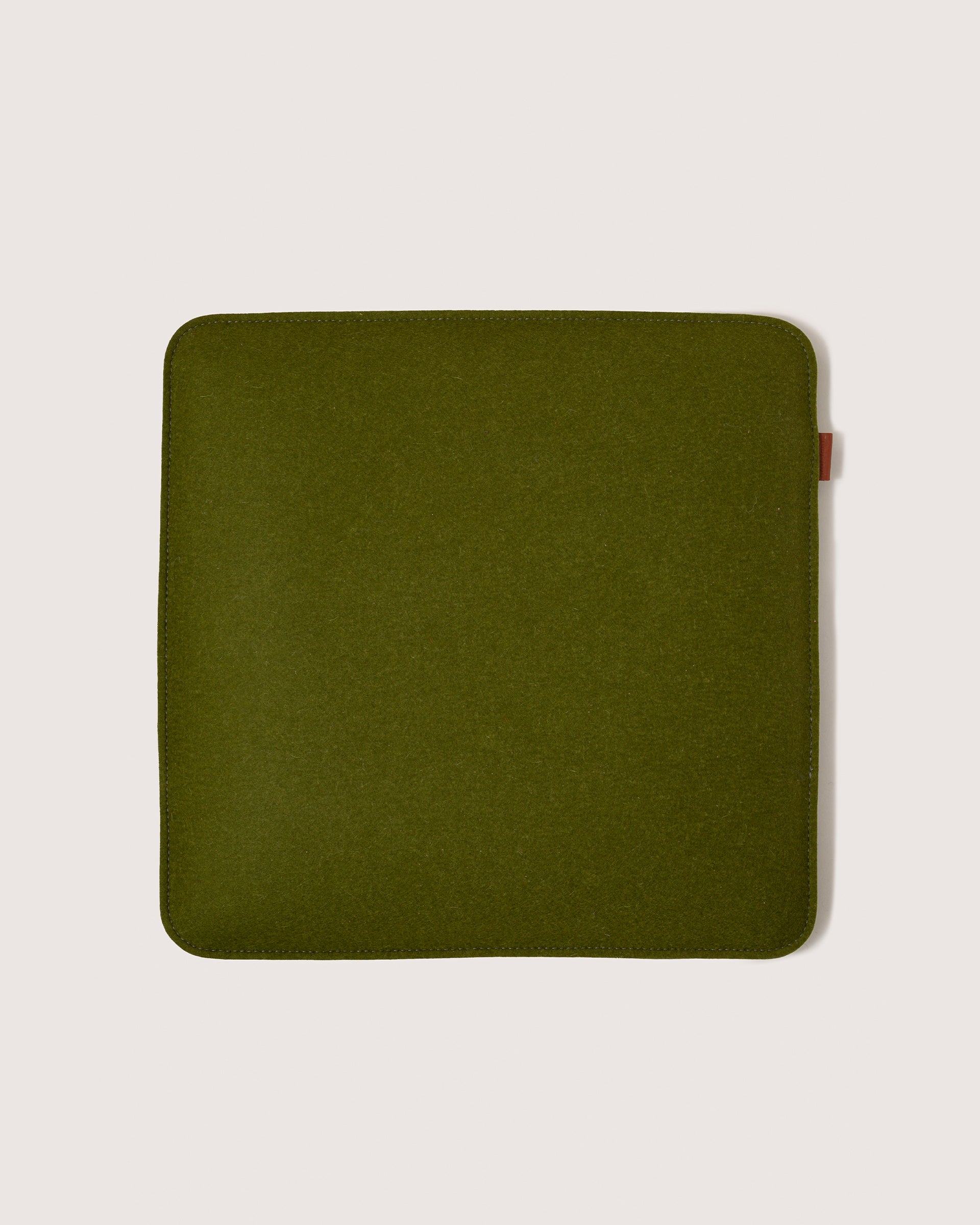 A Zabuton Merino Wool Felt Square Seat Pad by Graf Lantz in Moss Sienna, white background
