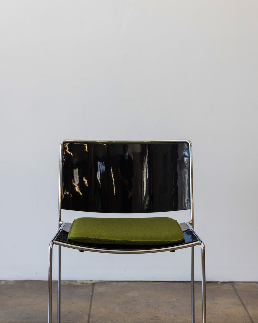A square Zabuton Merino Wool Felt Seat Pad by Graf Lantz in Moss Sienna on a black chair, front view