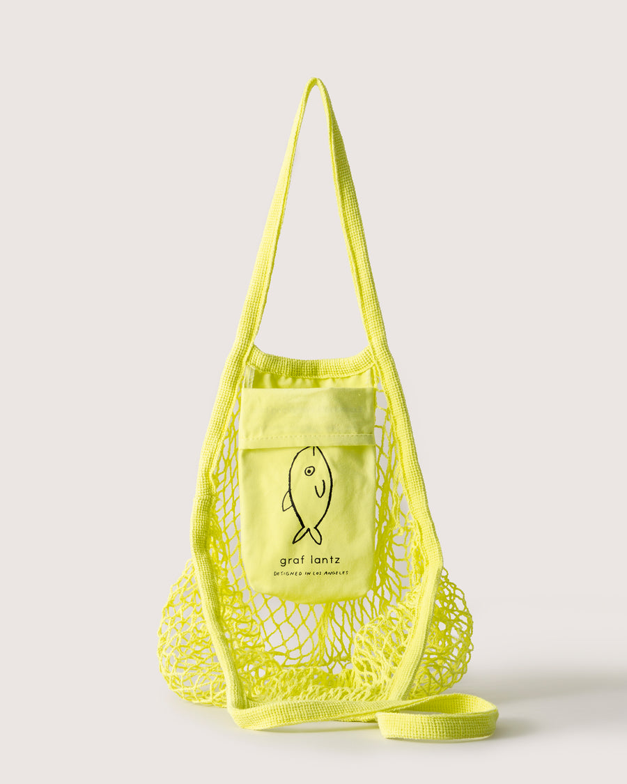 Reusable, washable, and ultra-versatile: thw citron-colored Ami Market Tote is a 100% cotton netting tote, collapses into its own pouch