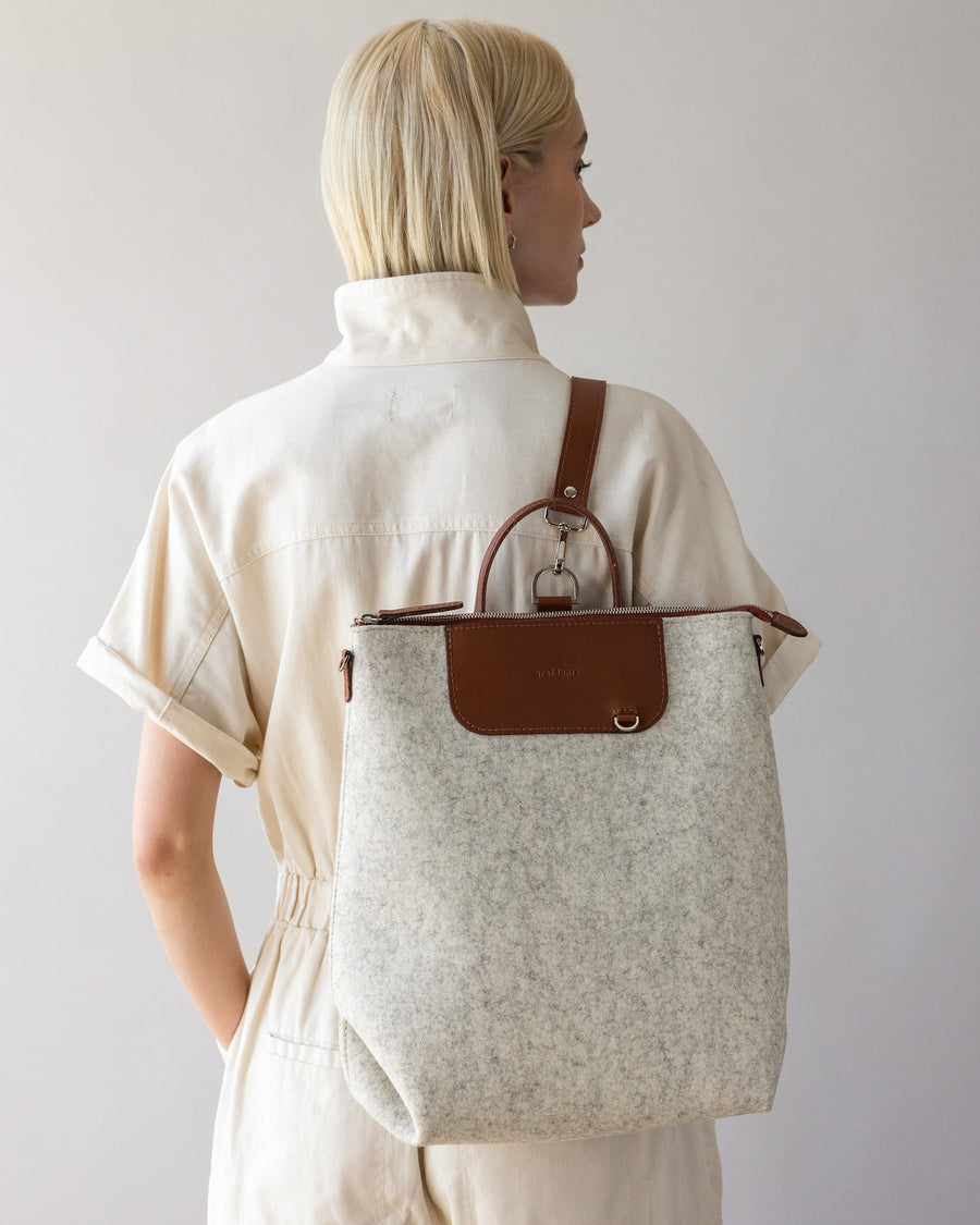 Woman with white Bedford Merino Wool Backpack on her back, rear view, white background