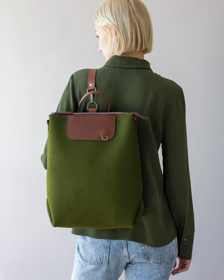 Woman with green Bedford Merino Wool Backpack on her back, rear view, white background