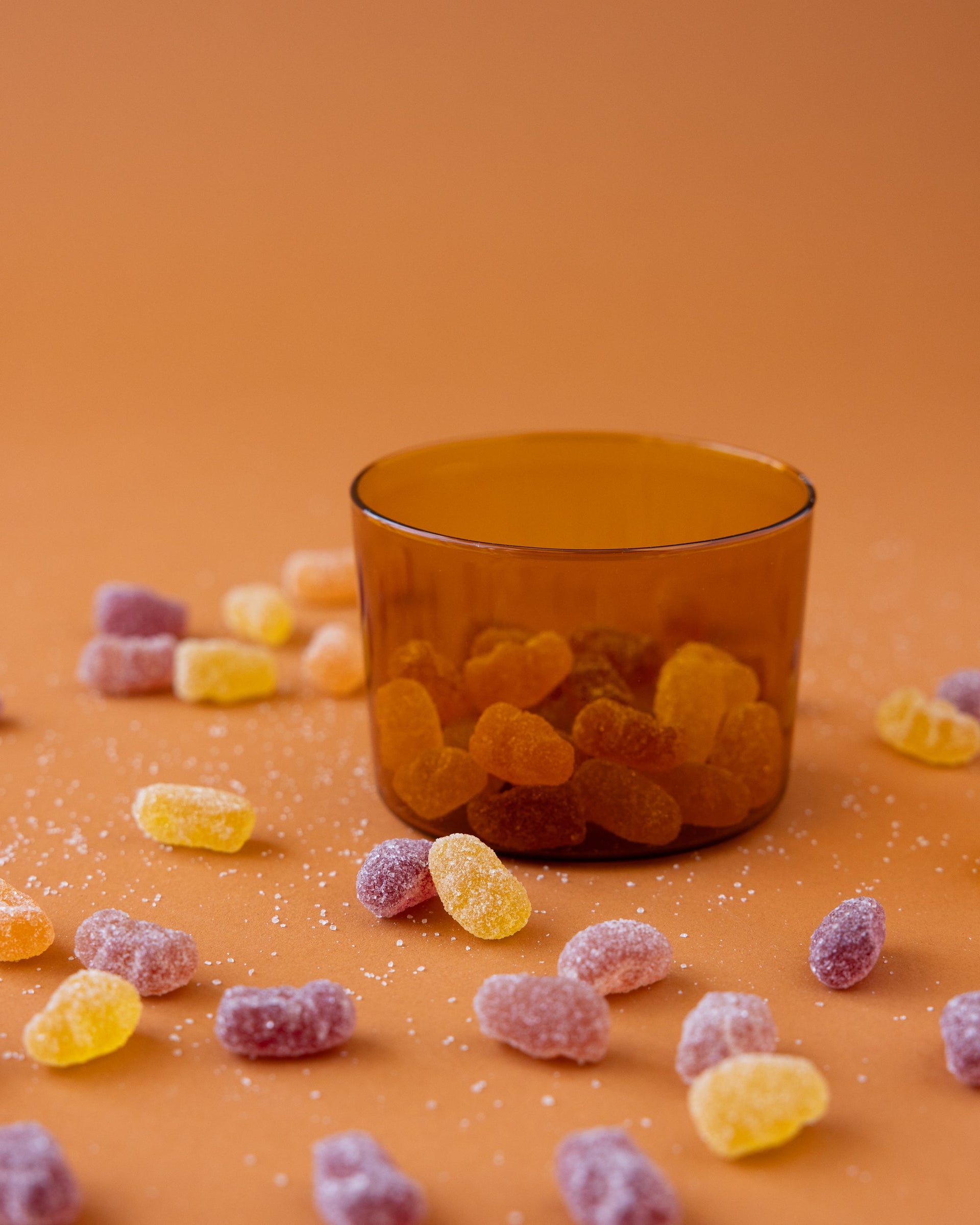 Small Glas Half Tumbler in color Burnt Orange used as snack bowl filled with candy