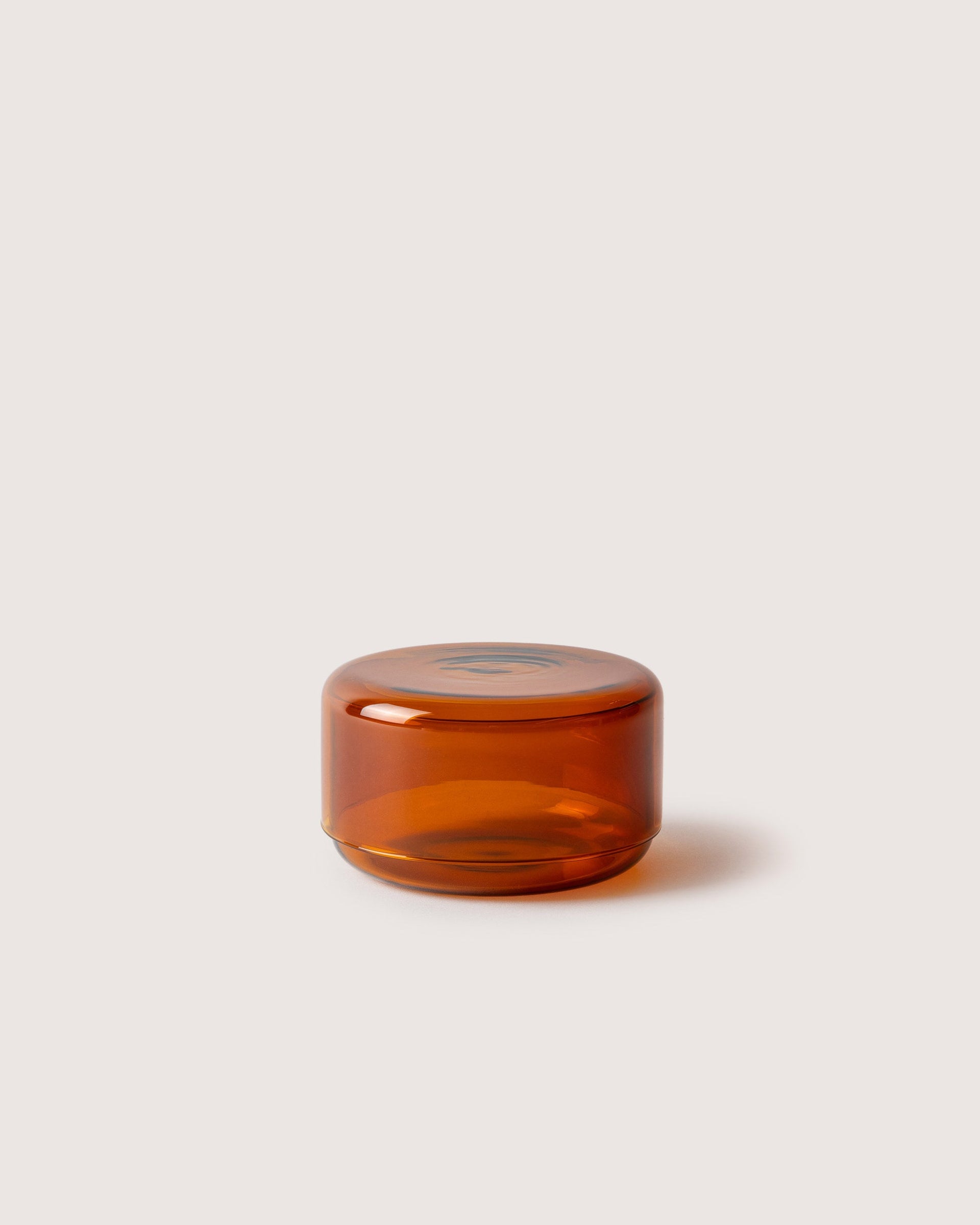 Small Lidded Container from Borosilicate glass in color burnt orange, white background