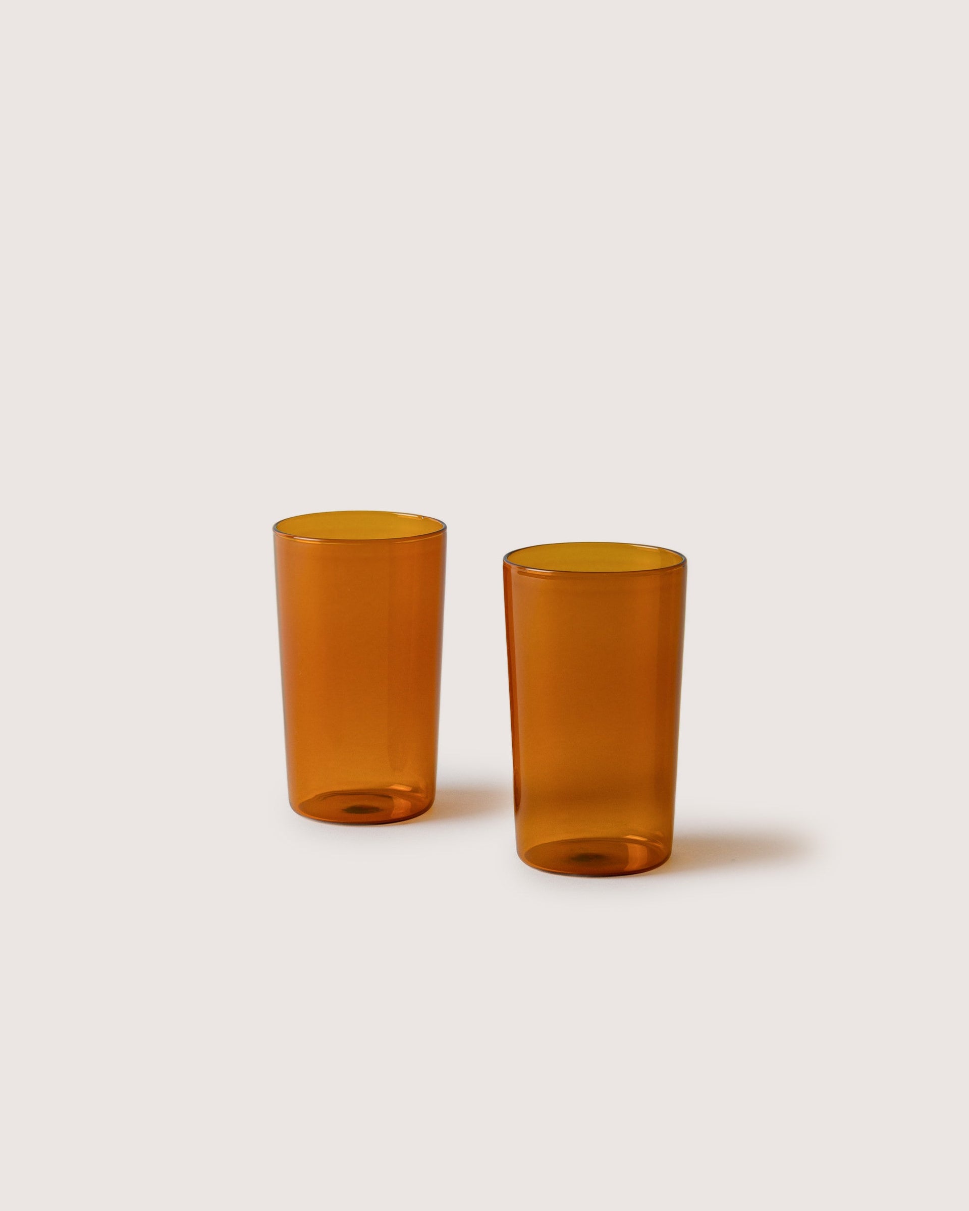 Two narrow Glas Tumbler in color Burnt Orange, white background