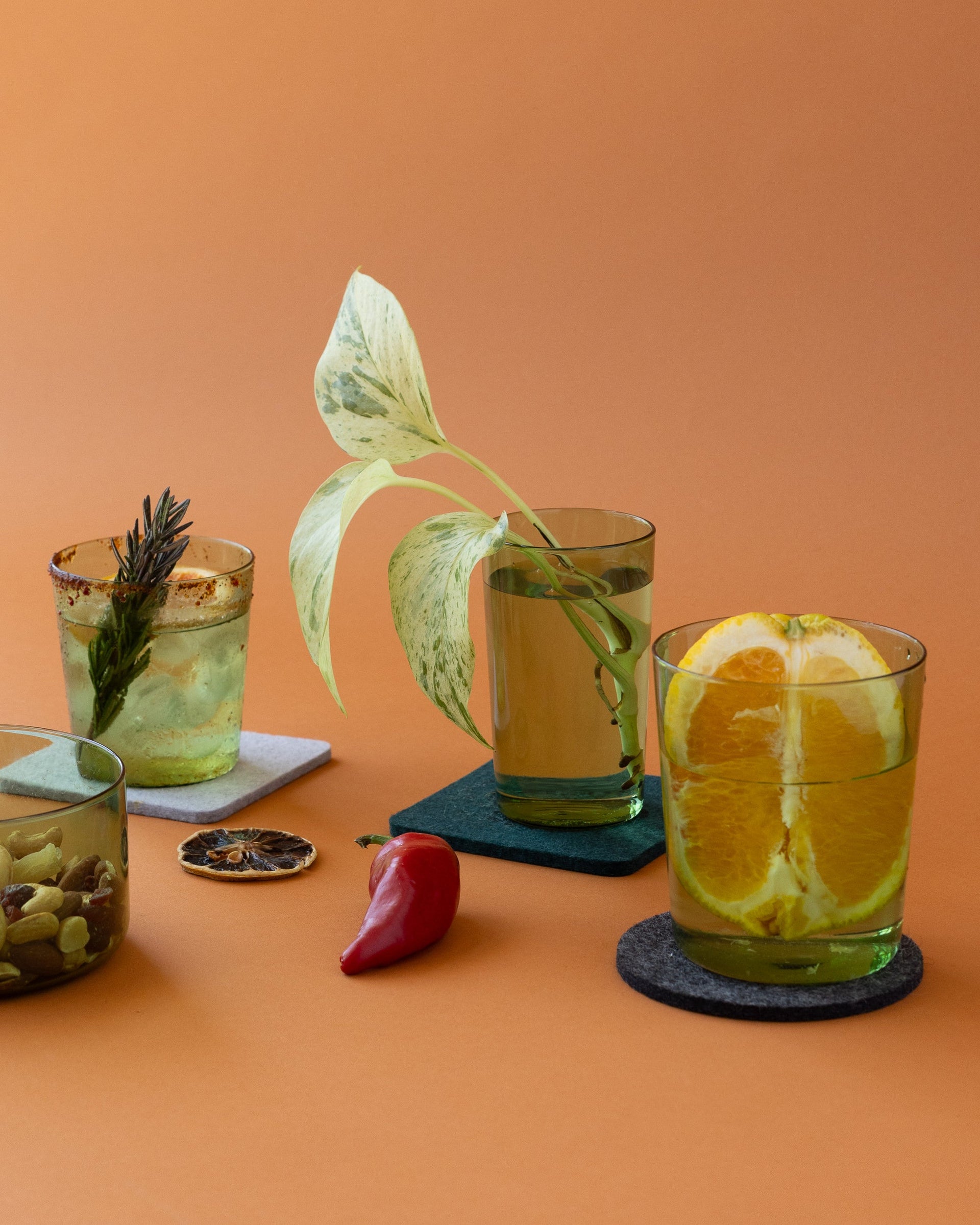 Selection of as cocktail decorated glasses and a small bowl filled with nuts in color Cactus by Graf Lantz, white background