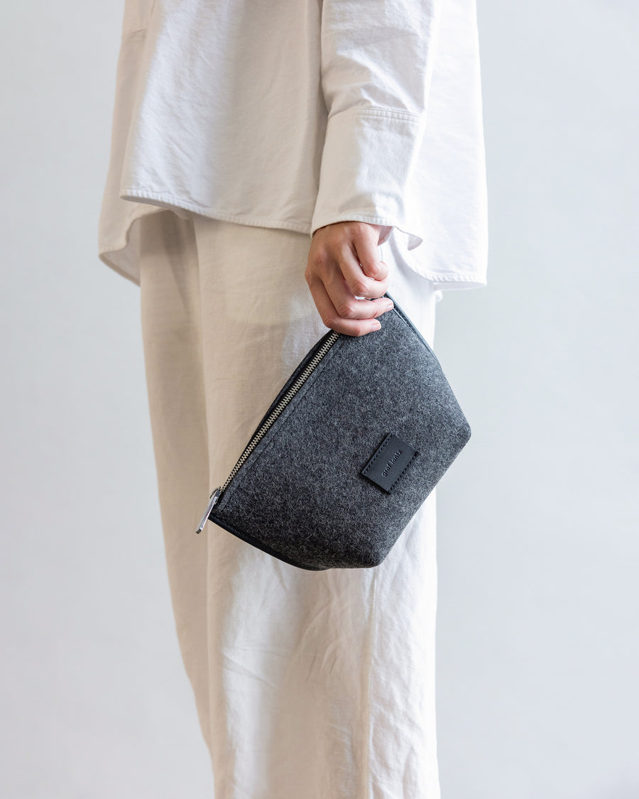 Standing woman with Hana Merino Wool Pouch in charcoal by Graf Lantz in her hand by her side